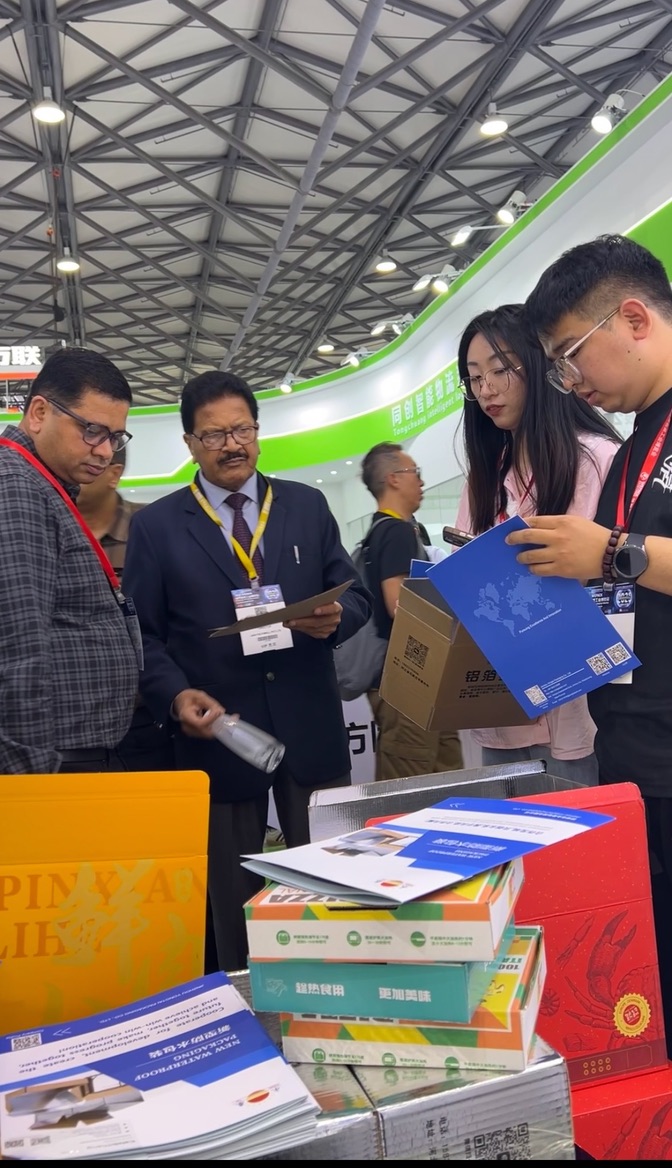International visitors reviewing Yongtai product literature and packaging samples